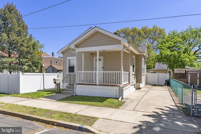 shotgun-style home with covered porch and driveway