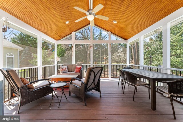 sunroom with a ceiling fan, outdoor dining area, vaulted ceiling, and healthy amount of natural light