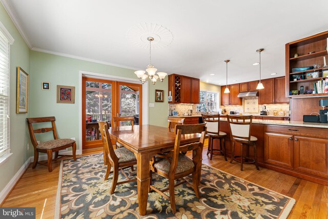 dining room with light wood-style floors, a chandelier, crown molding, baseboards, and recessed lighting