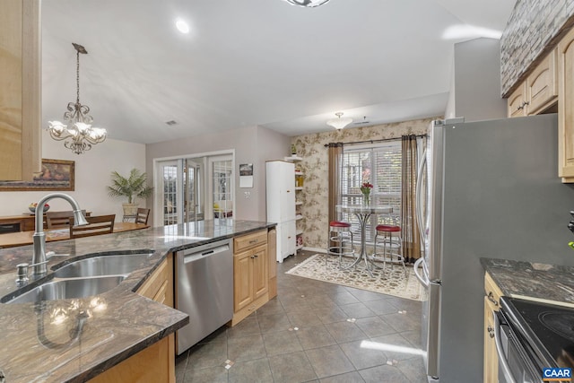 kitchen featuring stainless steel dishwasher, a sink, tile patterned floors, baseboards, and wallpapered walls