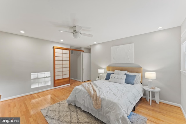 13429 Locksley Ln, Silver Spring, MD 20904 - bedroom with a barn door, wood finished floors, baseboards, recessed lighting, and a ceiling fan