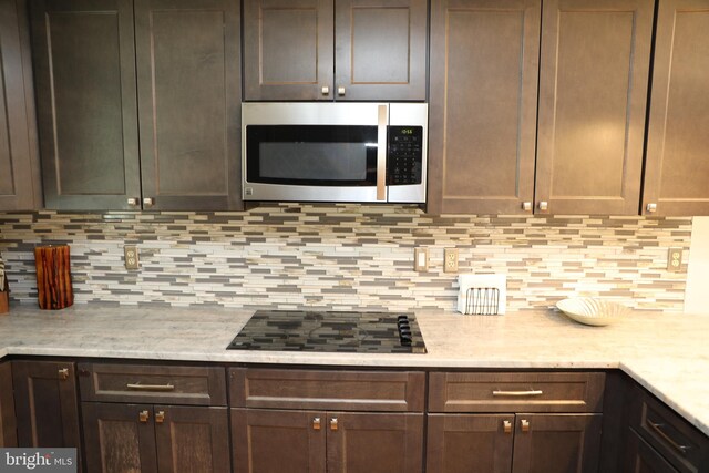 2616 Osage St, Hyattsville, MD 20783 - kitchen with stainless steel microwave, black electric cooktop, light countertops, and backsplash