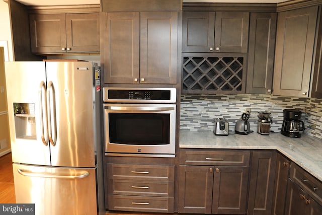 2616 Osage St, Hyattsville, MD 20783 - kitchen with stainless steel appliances, decorative backsplash, light stone counters, and dark brown cabinetry