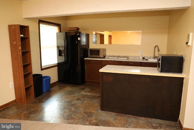 2616 Osage St, Hyattsville, MD 20783 - kitchen with black fridge, stainless steel microwave, a sink, baseboards, and a peninsula