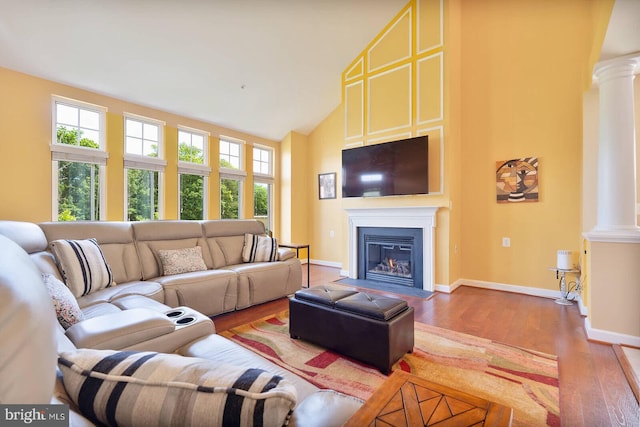 7419 Near Thicket Way, Laurel, MD 20707 - living room featuring ornate columns, high vaulted ceiling, wood finished floors, a fireplace with flush hearth, and baseboards