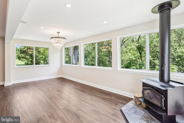 302 Fenwick Rd, Pilesgrove, NJ 08098 - unfurnished living room featuring a wood stove, baseboards, a chandelier, wood finished floors, and recessed lighting