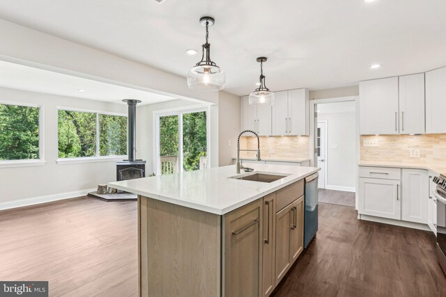 302 Fenwick Rd, Pilesgrove, NJ 08098 - kitchen with a sink, stainless steel appliances, dark wood finished floors, a wood stove, and decorative backsplash