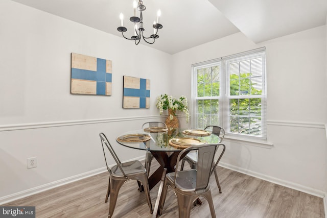 dining area with a chandelier, baseboards, and wood finished floors