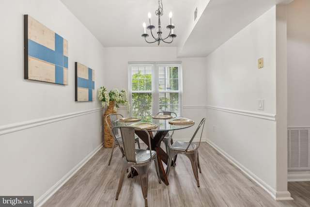 dining room featuring a chandelier, wood finished floors, and baseboards