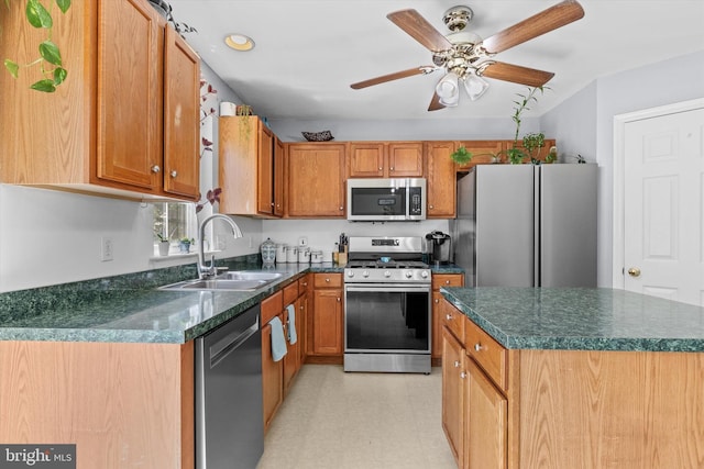 kitchen with appliances with stainless steel finishes, a sink, a ceiling fan, brown cabinets, and recessed lighting