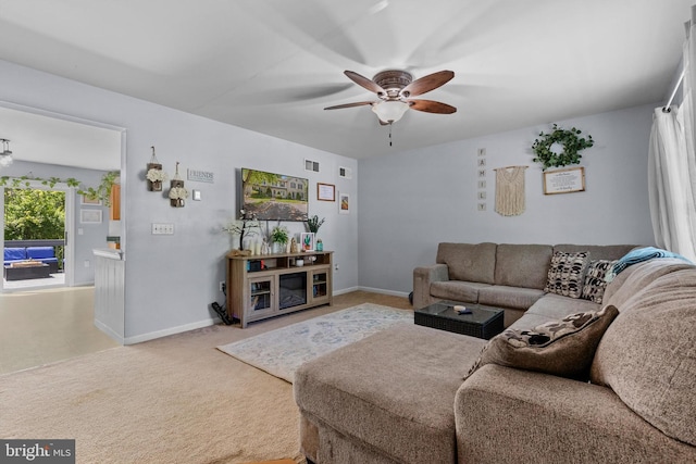 living area with a ceiling fan, baseboards, and carpet
