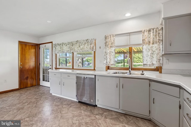 kitchen featuring dishwasher, a sink, light countertops, gray cabinets, and recessed lighting
