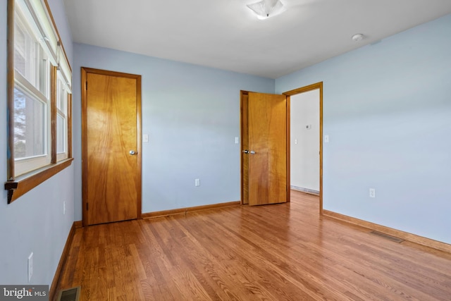 unfurnished bedroom featuring wood finished floors and baseboards