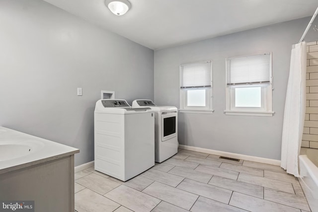 washroom featuring separate washer and dryer and baseboards