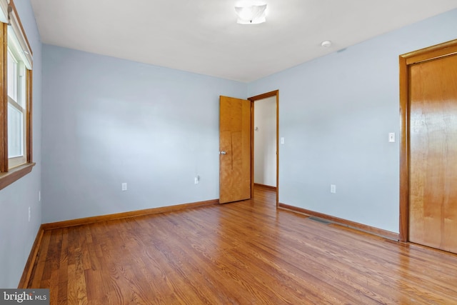 unfurnished bedroom featuring wood finished floors and baseboards