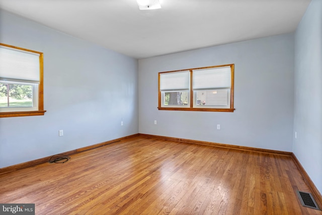 empty room featuring light wood finished floors and baseboards