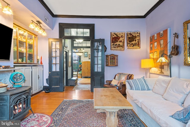 17 W Chase St, Baltimore, MD 21201 - living room featuring a wood stove, crown molding, and wood finished floors