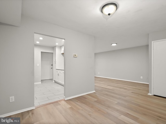 unfurnished room featuring light wood finished floors, baseboards, and recessed lighting