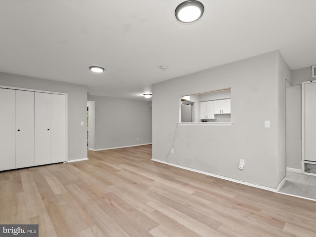 below grade area featuring light wood-type flooring and baseboards