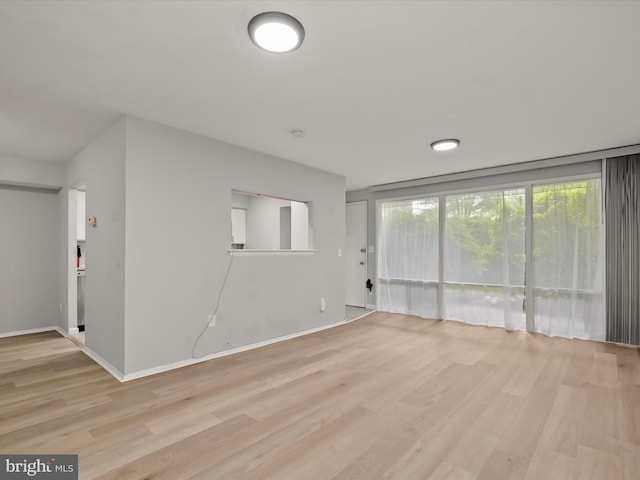 unfurnished living room featuring wood finished floors and baseboards