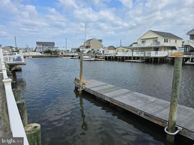 dock area featuring a water view and a residential view