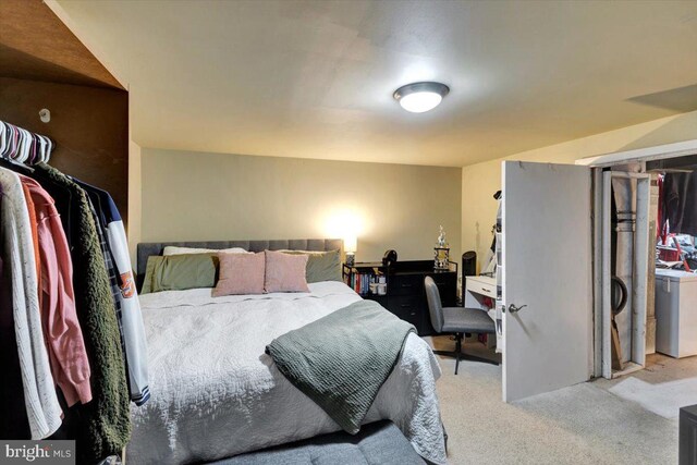 bedroom featuring washer / dryer and carpet flooring