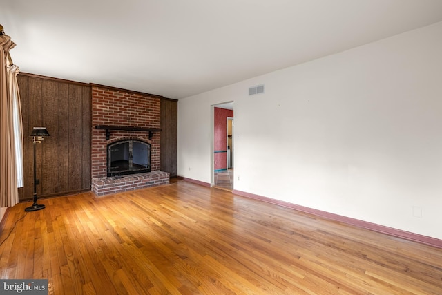 unfurnished living room featuring light wood-style floors, a fireplace, and baseboards