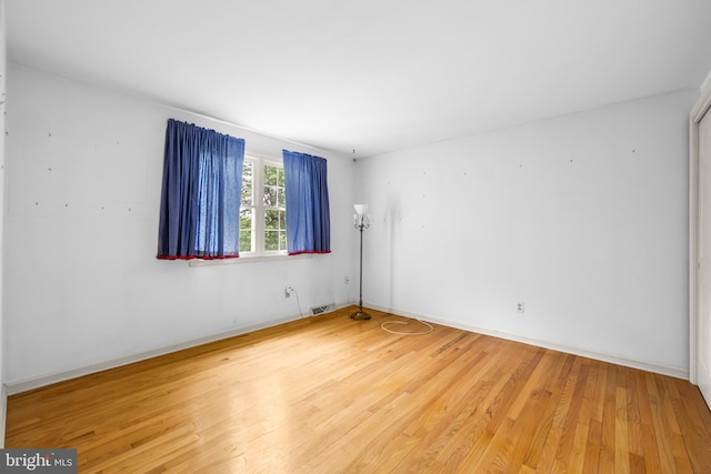 unfurnished room with wood finished floors and baseboards
