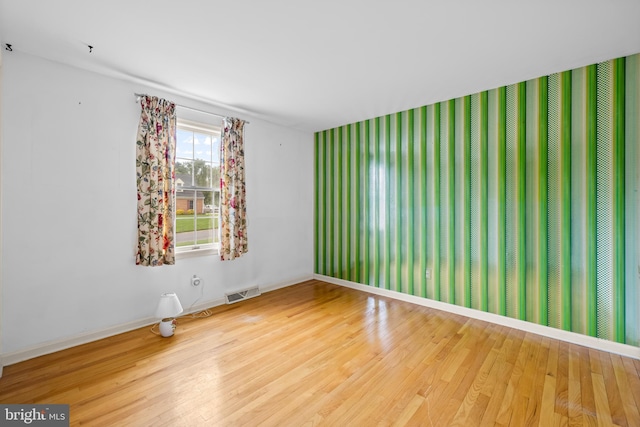 unfurnished room with wood finished floors and baseboards