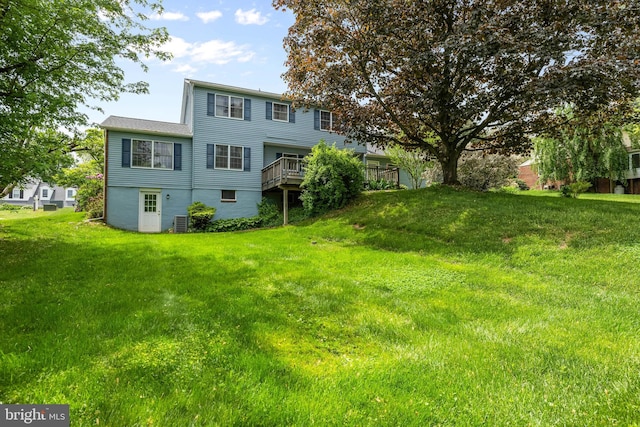 rear view of property with a lawn and a wooden deck