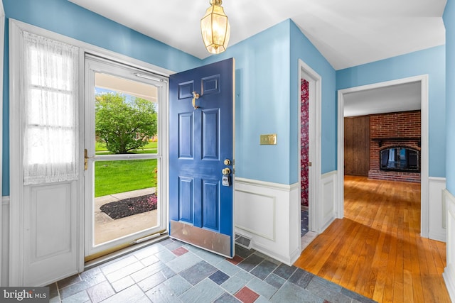 entryway featuring a wainscoted wall and a decorative wall