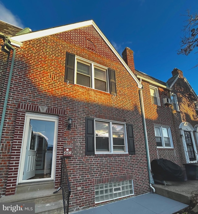 442 E Slocum St, Philadelphia, PA 19119 - rear view of house featuring brick siding, a chimney, and a wall unit AC