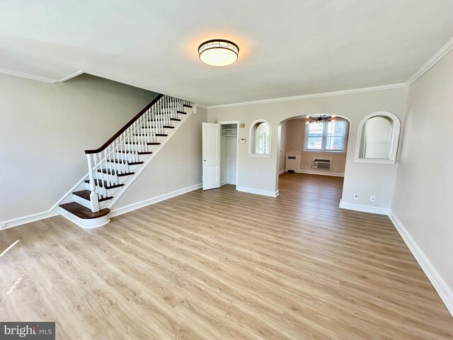 442 E Slocum St, Philadelphia, PA 19119 - unfurnished living room featuring wood finished floors, ornamental molding, baseboards, stairway, and arched walkways