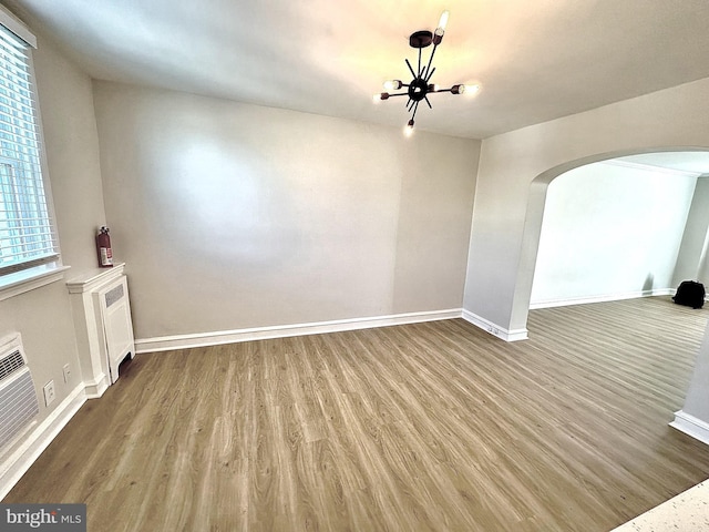 442 E Slocum St, Philadelphia, PA 19119 - unfurnished living room featuring arched walkways, wood finished floors, baseboards, and a chandelier