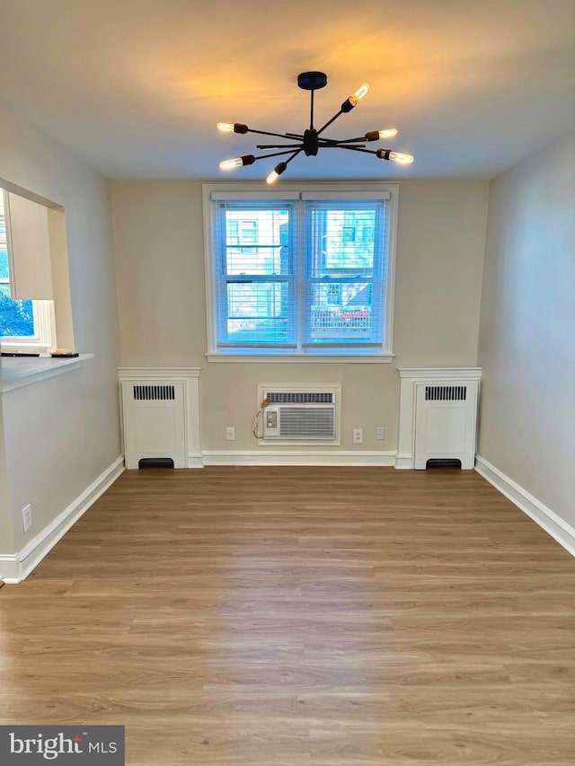 442 E Slocum St, Philadelphia, PA 19119 - unfurnished living room featuring radiator heating unit, a chandelier, a wall mounted air conditioner, and light wood finished floors