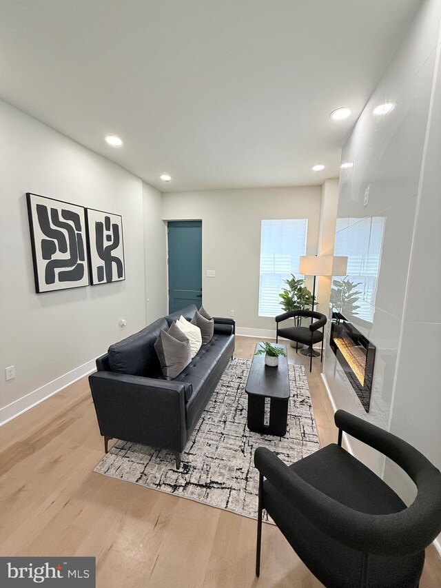 living area featuring light wood-style flooring, recessed lighting, and baseboards