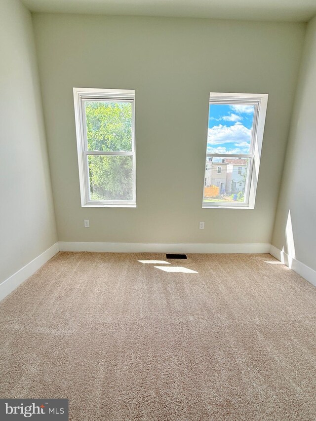 spare room featuring carpet flooring and baseboards