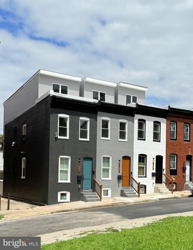 townhome / multi-family property featuring entry steps and brick siding