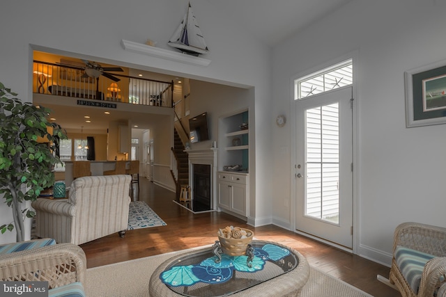 36725 Par Ln Unit 98, Frankford, DE 19945 - living area with wood finished floors, a towering ceiling, baseboards, a fireplace with raised hearth, and a ceiling fan