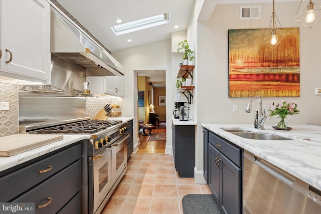 214 E Willow Grove Ave, Philadelphia, PA 19118 - kitchen with appliances with stainless steel finishes, a sink, a skylight, under cabinet range hood, and decorative backsplash