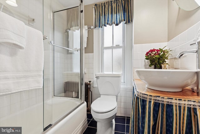 214 E Willow Grove Ave, Philadelphia, PA 19118 - bathroom with tile walls, a sink, tile patterned flooring, toilet, and enclosed tub / shower combo