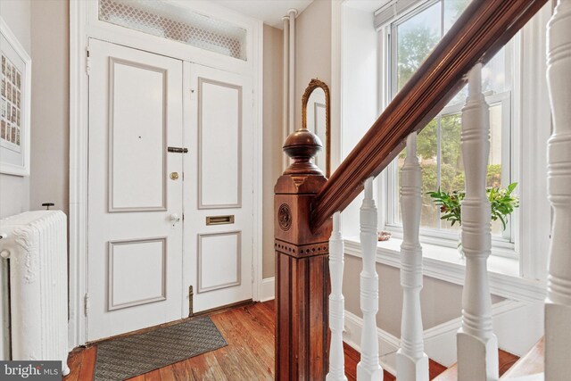 214 E Willow Grove Ave, Philadelphia, PA 19118 - foyer with radiator heating unit, light wood finished floors, and stairs