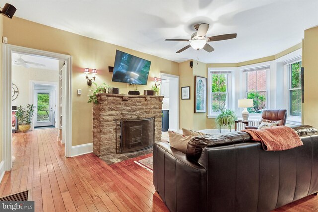 214 E Willow Grove Ave, Philadelphia, PA 19118 - living room with ceiling fan, light wood-style flooring, a stone fireplace, baseboards, and healthy amount of natural light