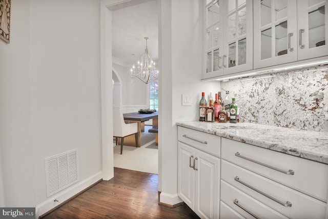 7845 Montvale Way, Mclean, VA 22102 - bar area with baseboards, dark wood-style floors, a chandelier, backsplash, and arched walkways