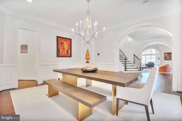 7845 Montvale Way, Mclean, VA 22102 - dining area with arched walkways, a chandelier, wood finished floors, crown molding, and a decorative wall