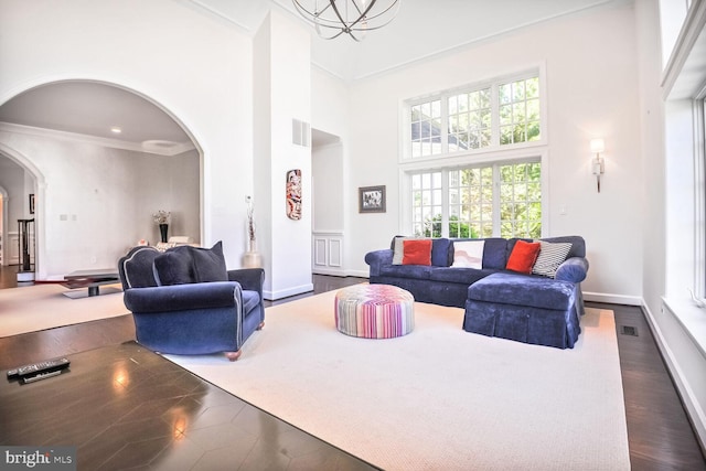 7845 Montvale Way, Mclean, VA 22102 - living area with arched walkways, a towering ceiling, dark wood-type flooring, ornamental molding, and baseboards