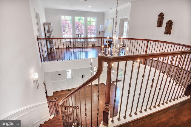 7845 Montvale Way, Mclean, VA 22102 - stairway featuring ornamental molding, wainscoting, a decorative wall, a chandelier, and a towering ceiling