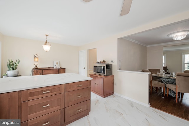 6005 Southward Way, Alexandria, VA 22315 - kitchen featuring stainless steel microwave, brown cabinets, light marble finish floors, hanging light fixtures, and crown molding
