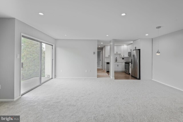 4425 Romlon St Unit 103, Beltsville, MD 20705 - unfurnished living room with light carpet, baseboards, recessed lighting, and a sink