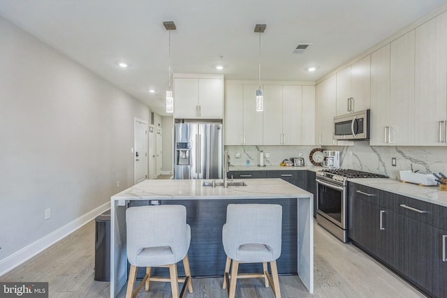 2812 Georgia Ave NW Unit 6, Washington, DC 20001 - kitchen with appliances with stainless steel finishes, a sink, light wood-style flooring, an island with sink, and recessed lighting